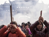 Worshippers pray with burning incense at the Longhua temple, 2013