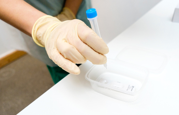Germany, Berlin, November 30, 2020: A medical staff member drips a sample of a test into a reader at a Covid-19 Quick Test Center in Berlin Kreuzberg. Corona case numbers in Germany remain almost unchanged despite the "lockdown light" in place since November 2, 2020. From November 23, 2020 up to 500 people are to be tested for the corona virus daily under medical supervision of Dr. Dietmar Peikert und Sevim Saygin at the Covid-19 test facility in Prinzessinnenstraße 14, operated by KDP BioMed GmbH.